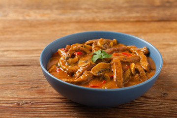 Boeuf, Stroganow, Strogonow. Classic, Russian beef stew.  Served in a blue bowl. Front view. Natural background.