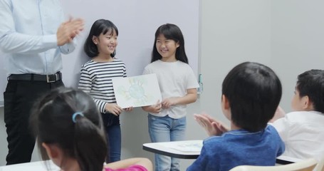 Little girl present drawing picture at front of classroom for saving world project. Volunteer, Nature and Education concept.