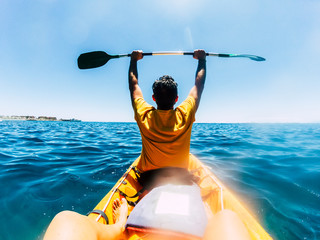 Obraz premium Travel and enjoying lifestyle people on summer holiday vacation enjoying a tour with kayak on the blue ocean - happiness and freedom couple in outdoor sea leisure activity together