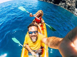 Selfie couple with top vertical point of view - happy active adult people enjoy kayak at the ocean...
