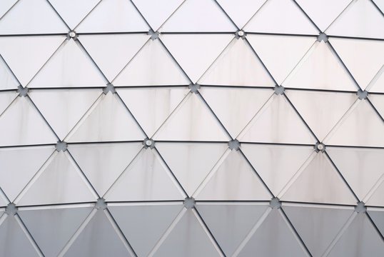 Close up a glass surface of a triangle pattern inside a high building in the city