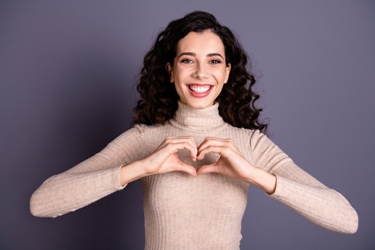 Close up photo pretty nice she her lady girlish beaming smile making hands arms fingers heart shape figure form symbolizing cardiac health wear casual pastel sweater pullover isolated grey background