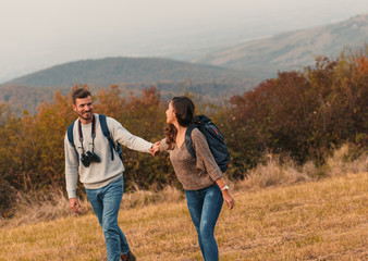 Fototapeta na wymiar Young couple enjoying hiking together through the countryside.
