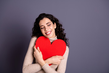 Close up photo beautiful she her lady overjoyed hands arms hold big large red paper heart form figure close chest invitation date prom wear casual pastel sweater pullover isolated grey background