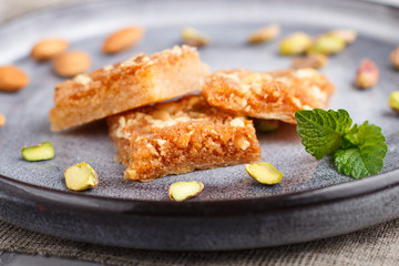 traditional arabic sweets in gray ceramic plate on a gray concrete background. close up.