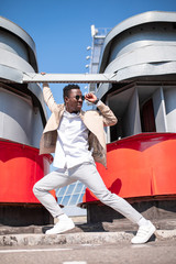 Handsome black young man in a jacket and white shirt on the street. Businessman