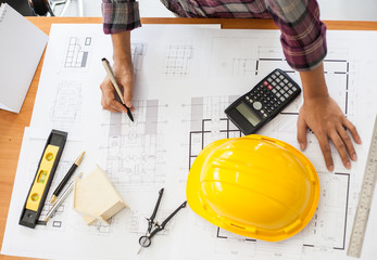 Construction and building concept. Engineers or architect holding a pen with drawings in...