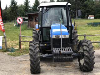 Blue tractor near the field. Agricultural industry 