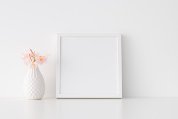 Fototapeta na wymiar White square frame mockup with pink oleander in a vase.