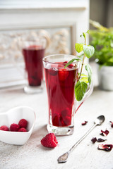 Red hibiscus tea in a transparent glass against the background of a vintage wall