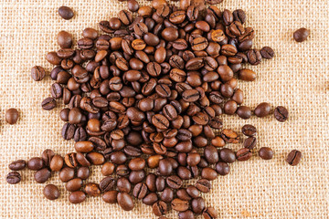 Coffee beans on a background of burlap. Place for text. Concept of making coffee, coffees.