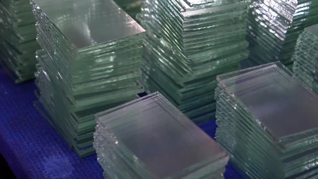 Many small pieces of hardened sheets of clear glass, cut to size as factory product samples