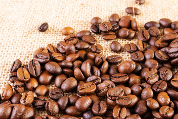 Coffee beans on a background of burlap. Place for text. Concept of making coffee, coffees.