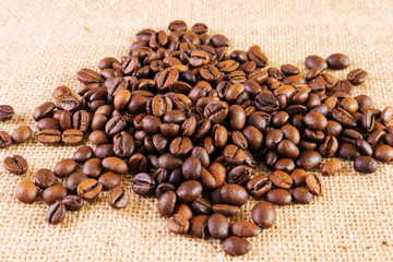 Coffee beans on a background of burlap. Place for text. Concept of making coffee, coffees.