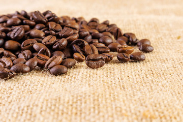 Coffee beans on a background of burlap. Place for text. Concept of making coffee, coffees.
