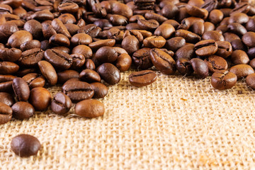 Coffee beans on a background of burlap. Place for text. Concept of making coffee, coffees.