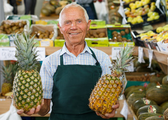 Seller proffering fruits and vegetables