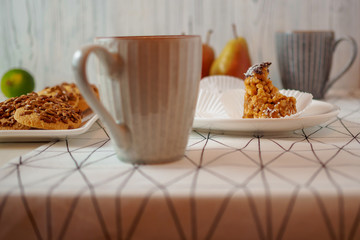 bitten off funnel cakes bicolor forelle pear cookies coffee mugs on a geometric patterned tablecloth