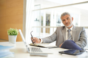 Mature businessman sitting casually at desk