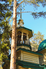 Golden domes with crosses on the  temple church chapel hut cottage, a religious christian building of wooden logs with emerald green tile bottom view
