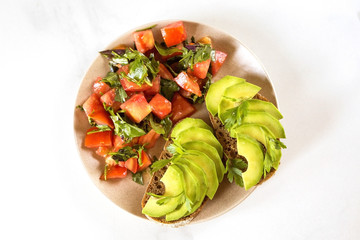 Healthy breakfast toasts with avocado and tomato salad.