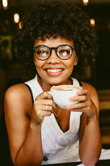 African female having coffee at cafe