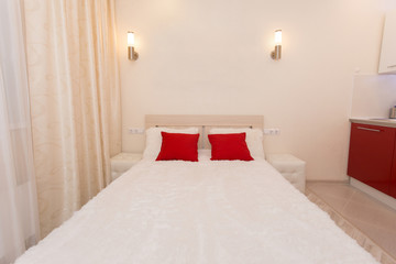 Double bed with bedside tables and red pillows