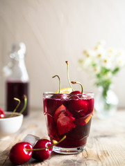 Kirschsaft selbstgemacht im rustikalen Stil, weißer Hintergrund, Zutaten, Sommergetränk