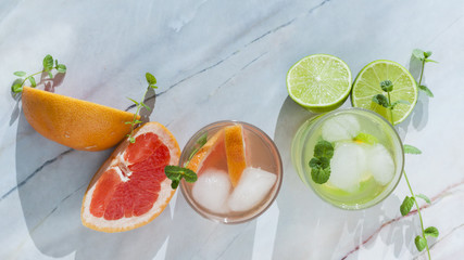 Glasses of citrus drink with sliced fruit