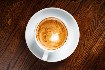 cup of cappuccino on the wooden background