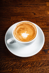 cup of cappuccino on the wooden background