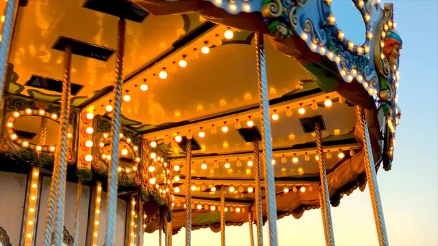 A merry-go-round, or crousel spinning at sunset