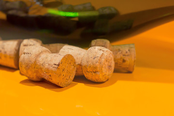 Few wine bungs on the orange tble, dark green bottle background. Close-up, copy space