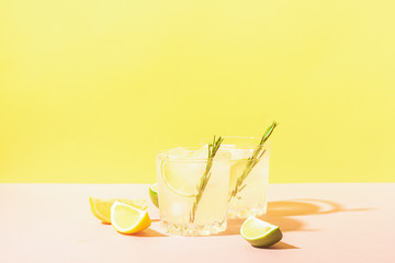 Italian traditional drink limoncello in glass goblets on a pastel yellow pink background. Alcoholic cocktail. Copy space.