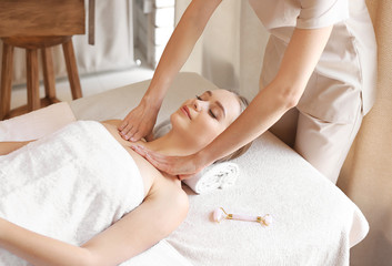 Obraz na płótnie Canvas Beautiful young woman receiving massage in spa salon