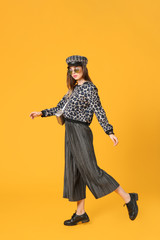 Fashionable young woman on color background