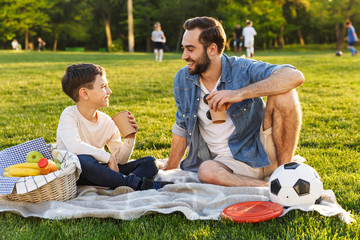 Happy young father having a picnic with his little son