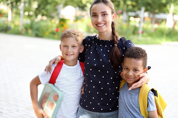 Portrait of mother and her little sons with school lunch outdoors