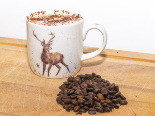 cup of coffee and beans on wooden table