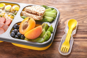 School lunch box with tasty food on wooden table