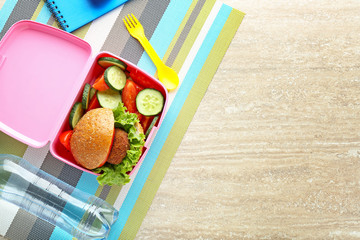 School lunch box with tasty food on wooden table
