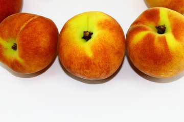 Three ripe peaches on a white background