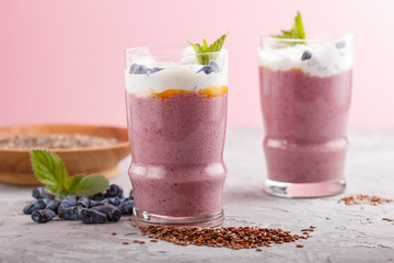 smoothie with honeysuckle, linen and chia in a glass on gray concrete background. side view.