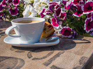 white cup of coffee with delicious fruit cake outdoor