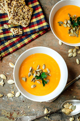 Pumpkin and carrot soup on rustic wooden background