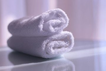 Rolled towels. White rolled towels on table with reflection. Morning relaxation concept.