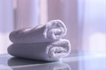 Rolled towels. White rolled towels on table with reflection. Morning relaxation concept.