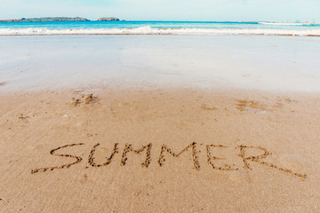 Summer (inscription) on the beach (sand) by the sea or ocean. Summer mood concept.
