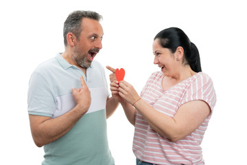 Woman gifting red heart to man