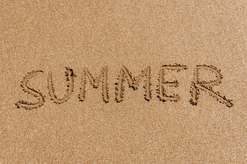 Summer (inscription) on the beach (sand) by the sea or ocean. Summer mood concept.